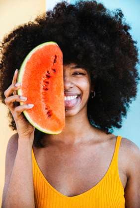 Creative Highlights Symbolbilder Playful young woman with watermelon slice in front of face model released Symbolfoto DAF00058
