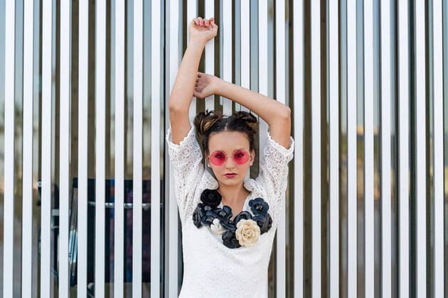IMAGO Creative: Clickbait, Modetrends Fashionable teenage girl wearing sunglasses standing with hands raised in front of metallic wall model released Symbolfoto DLTSF01911