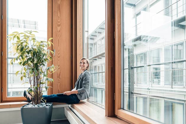 Female entrepreneur smiling while sitting by window model released Symbolfoto property released JOSEF04784