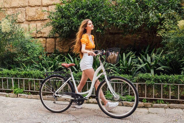 Young woman with bicycle walking on footpath model released Symbolfoto JRVF00768