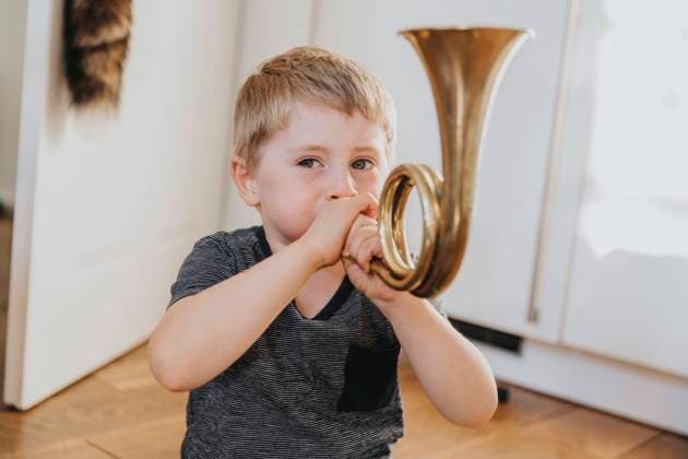 Boy playing tuba while sitting at home model released Symbolfoto property released MFF08021