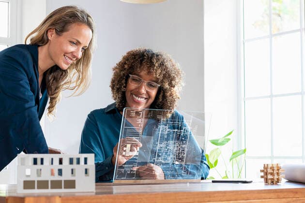 Mid adult businesswomen planning strategy on futuristic digital tablet at office model released Symbolfoto property released SBOF03979