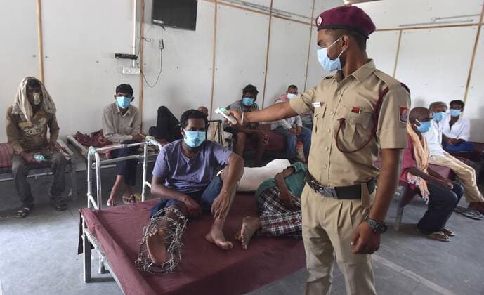 NEW DELHI, INDIA - JUNE 25: A DCD worker thermal scanning a Homeless man before a shot of Covid vaccine during the First Vaccination camp for homeless is starting at Yamuna Pushta Night Shelter near Nigam Bodh Ghat opposite Hanuman Mandir on June 25, 2021 in New Delhi, India. (Photo by Sonu Mehta Hindustan Times) Covid Vaccination Camp For Homeless