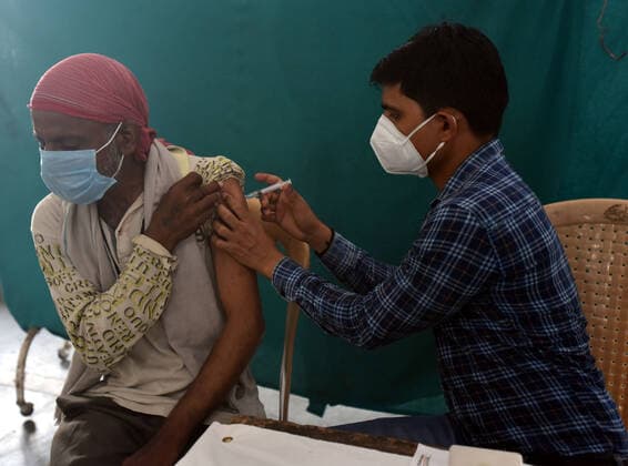 NEW DELHI, INDIA - JUNE 25: A health worker administers a shot of Covid vaccine to a beneficiary Home Less Man, First Vaccination camp for homeless is starting at Yamuna Pushta Night Shelter near Nigam Bodh Ghat opposite Hanuman Mandir on June 25, 2021 in New Delhi, India. (Photo by Sonu Mehta Hindustan Times) Covid Vaccination Camp For Homeless