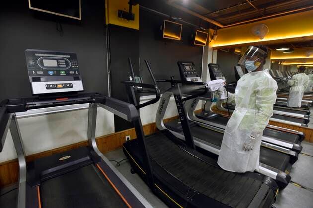 NEW DELHI, INDIA JUNE 27: Workers in PPE coveralls sanitizing the premises of a gym, at A.K.Fitness 24x7 in Jangpura, on June 27, 2021 in New Delhi, India. Gyms and yoga centres have been allowed to reopen in Delhi from Monday at 50% capacity, an official government order said. Banquet halls, marriage halls, and hotels have also been permitted to host weddings, but the number of guests has been capped at 50, the order said. (Photo by Sanjeev Verma Hindustan Times ) Delhi Unlock 5: Gyms, Banquet Halls, Hotels To Open From Monday