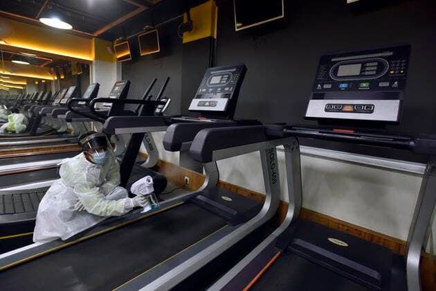 NEW DELHI, INDIA JUNE 27: Workers in PPE coveralls sanitizing the premises of a gym, at A.K.Fitness 24x7 in Jangpura, on June 27, 2021 in New Delhi, India. Gyms and yoga centres have been allowed to reopen in Delhi from Monday at 50% capacity, an official government order said. Banquet halls, marriage halls, and hotels have also been permitted to host weddings, but the number of guests has been capped at 50, the order said. (Photo by Sanjeev Verma Hindustan Times ) Delhi Unlock 5: Gyms, Banquet Halls, Hotels To Open From Monday