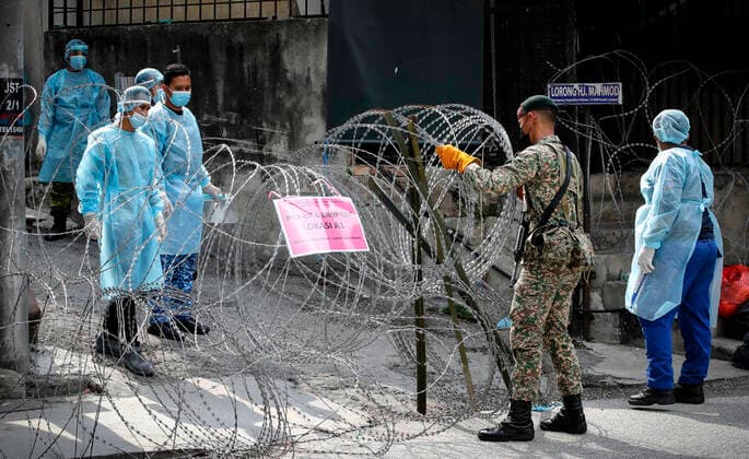 June 27, 2021, Kuala Lumpur, Malaysia: Malaysian soldier adjusting the barbwire at the Segambut Dalam housing area which was placed under the enhanced movement control order (EMCO) due to surge in the number of COVID-19 daily cases recorded..Malaysia government announced the one month full lockdown which is due on Monday will be extended due to the daily high number of coronavirus infections cases reported. Kuala Lumpur Malaysia - ZUMAs197 20210627_zaa_s197_071 Copyright: xWongxFokxLoyx