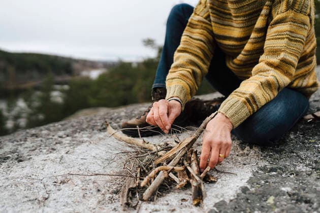 Low section of woman with sticks preparing campfire at mountain Sweden, Stockholm Archipelago, model released Copyright: xMaskotx , MA87287