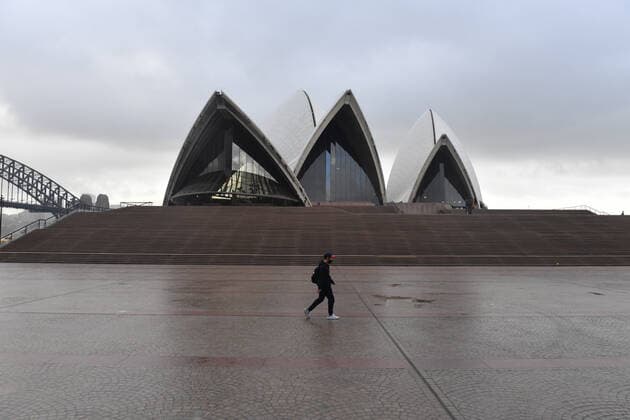 NSW CORONAVIRUS COVID19, A pedestrian walks past an empty Sydney Opera House in Sydney, Tuesday, June 29, 2021. More than five million people in Greater Sydney and its surrounds have gone into a 14-day lockdown as health authorities try to regain control of a coronavirus outbreak. ( NO ARCHIVING, EDITORIAL USE ONLY, NO USE IN BOOKS WITHOUT CONSENT SYDNEY NSW AUSTRALIA  Copyright: xMICKxTSIKASx 20210629001553444180