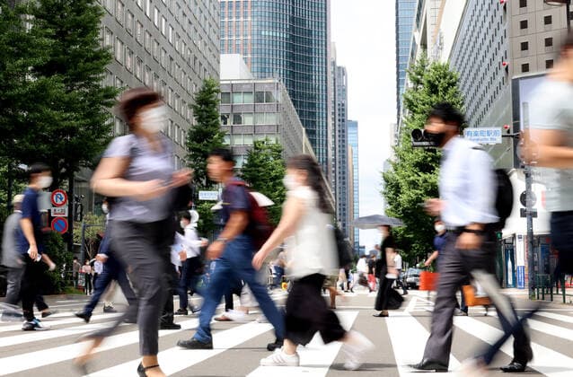 June 29, 2021, Tokyo, Japan - People cross a road in front of the Yurakucho station in Tokyo on Tuesday, June 29, 2021. Japan s jobless rate in May worsened to 3.0 percent, announced by Internal Affairs Ministry on June 29, the highest level in five months amid outbreak of the new coronavirus.  (163555448)
