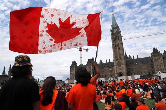 News Bilder des Tages July 1, 2021, Ottawa, on, Canada: Protesters wave a flag at Parliament Hill in Ottawa at a Cancel Canada Day protest in response to the discovery of unmarked indigenous graves at residential schools on Thursday, July 1, 2021. Ottawa Canada  - ZUMAc35_ 20210701_zaf_c35_096 Copyright: xPatrickxDoylex