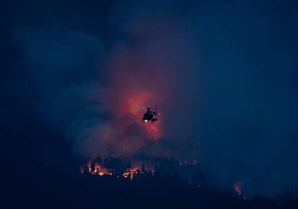 July 1, 2021, Lytton, BC, Canada: A helicopter flies past a wildfire burning in Lytton, B.C., at dusk on Thursday, July 1, 2021. Lytton Canada  - ZUMAc35_ 20210701_zaf_c35_321 Copyright: xDarrylxDyckx