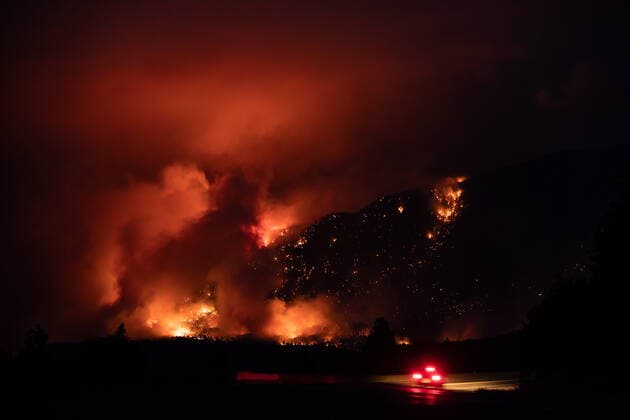 July 1, 2021, Lytton, BC, Canada: A motorist travels on the Trans-Canada Highway as a wildfire burns on the side of a mountain in Lytton, B.C., Thursday, July 1, 2021. Lytton Canada  - ZUMAc35_ 20210701_zaf_c35_322 Copyright: xDarrylxDyckx