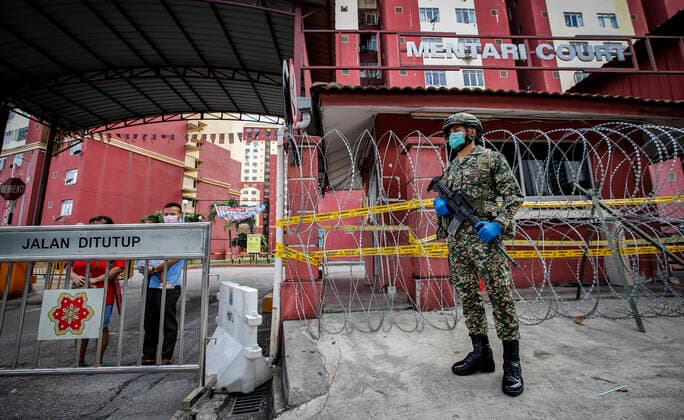 July 2, 2021, Kuala Lumpur, Malaysia: An armed soldier wearing a mask and gloves stands on guard outside a residential area placed under the enhanced movement control order (EMCO) due to surge in the number of COVID-19 daily cases recorded..Malaysia government starts to further tighten the movement control and imposes lockdown in state of Selangor and parts of Kuala Lumpur, due to the daily high number of coronavirus infections cases reported. Kuala Lumpur Malaysia - ZUMAs197 20210702_zaa_s197_069 Copyright: xWongxFokxLoyx