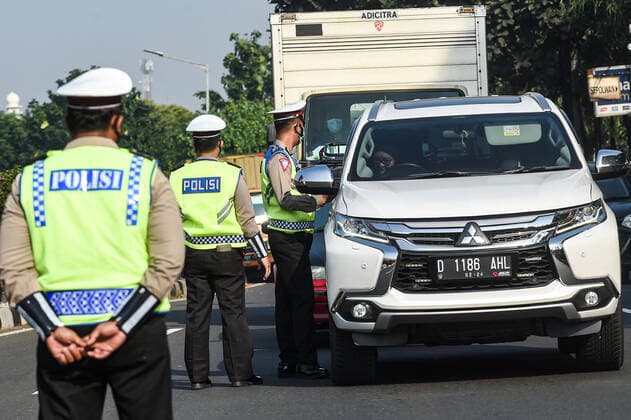 (210703) -- JAKARTA, July 3, 2021 -- Police officers stop a woman without a face mask on her car in Jakarta, Indonesia, July 3, 2021. The Indonesian government has decided to deploy 53,000 personnel for emergency community activity restrictions (locally known as PPKM) to be imposed in Java and Bali from July 3 to 20, a senior police officer said on Friday. ) INDONESIA-JAKARTA-COVID-19-RESTRICTIONS AgungxKuncahyaxB. 