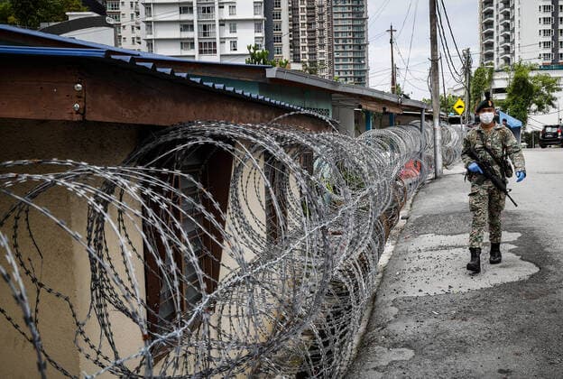 July 3, 2021, Kuala Lumpur, Malaysia: A soldier wearing a mask walks near a barbwire at the Segambut Dalam housing area which was placed under the enhanced movement control order (EMCO) due to surge in the number of COVID-19 daily cases recorded..Malaysia government starts to further tighten the movement control and imposes lockdown in state of Selangor and parts of Kuala Lumpur, due to the daily high number of coronavirus infections cases reported. Kuala Lumpur Malaysia - ZUMAs197 20210703_zaa_s197_002 Copyright: xWongxFokxLoyx