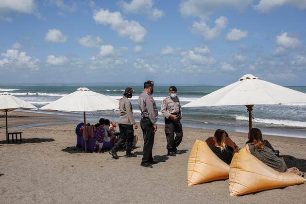 Emergency Public Activity Restriction Amid Covid 19 In Bali Polices urges visitors to leave the beach during emergency public activity restriction amid COVID-19 pandemic in Canggu Beach, Bali, Indonesia on July 3 2021. Indonesian government imposes emergency public activity restriction across the nation in orange and red zone of COVID-19 infections, starting from 3rd to 20th July 2021. During the restriction, public areas, tourism spots, shopping mall must be closed all the time. Restaurants only allowed for take away service and supermarket must be closed at 8 PM. Lately, the number of COVID-19 cases in Indonesia surges in major cities in Java and Bali Island. Bogor Bali Indonesia christo-policesu210703_npVFE  Copyright: xJohanesxChristox