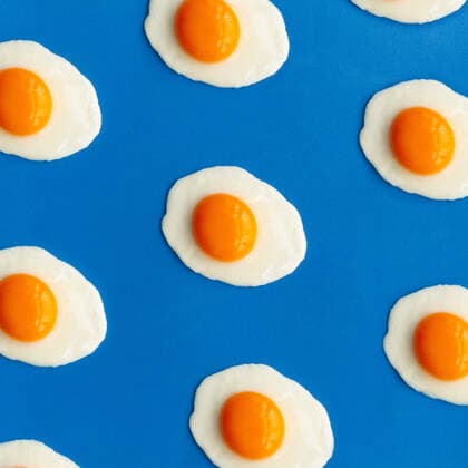 Row of fried eggs on a blue background Copyright: xLeirexGamboax Model Released