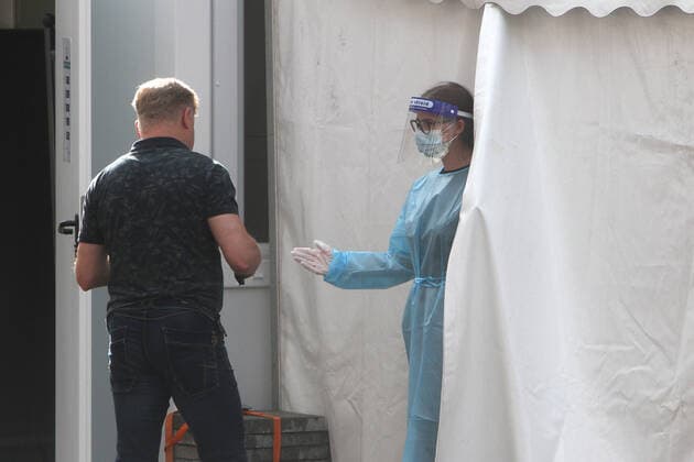 Employee at a Corona testing center in downtown Heidelberg talks to a customer who wants to take a free citizens test, Baden Württemberg, Germany
