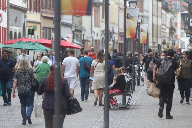 People take advantage of the warm weather mostly without masks in the crowded shopping street and pedestrian zone Hauptstraße in downtown Heidelberg, Baden Württemberg, Germany