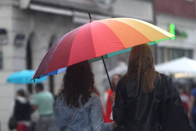 People walking with umbrellas during a rain shower in downtown Heidelberg, Baden Württemberg, Germany