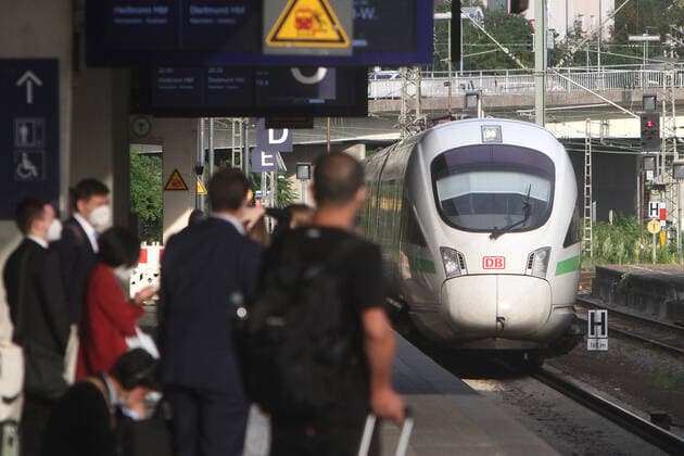 Following the easing measures and the lifting of travel restrictions during the coronavirus crisis, many more people are using DB Deutsche n Bahn long-distance trains again Masks-wearing passengers in suits await the arrival of a DB Deutsche Bahn ICE train at the main station in Heidelberg, Baden Württemberg, Germany