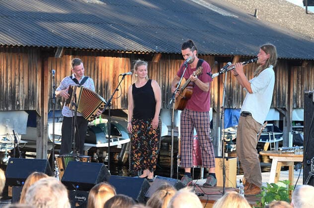 Concert of the Peter Mayer Hofkapelle, In the Bootswerft Frauscher in Gmunden, as part of the Salzkammergut Festwochen Gmunden, on 09 07 21 The picture shows from l to r Andreas Jamnik, Styrian harmonica and vocals, Nora Mayer, vocals and percussion, Peter Mayer, guitar and vocals, Mic