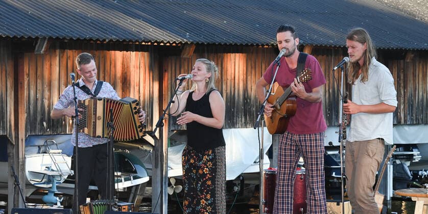 Concert of the Peter Mayer Hofkapelle, In the Bootswerft Frauscher in Gmunden, as part of the Salzkammergut Festwochen Gmunden, on 09 07 21 The picture shows from l to r Andreas Jamnik, Styrian harmonica and vocals, Nora Mayer, vocals and percussion, Peter Mayer, guitar and vocals, Mic