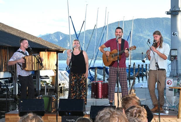 Concert of the Peter Mayer Hofkapelle, In the Bootswerft Frauscher in Gmunden, as part of the Salzkammergut Festwochen Gmunden, on 09 07 21 The picture shows from l to r Andreas Jamnik, Styrian harmonica and vocals, Nora Mayer, vocals and percussion, Peter Mayer, guitar and vocals, Mic
