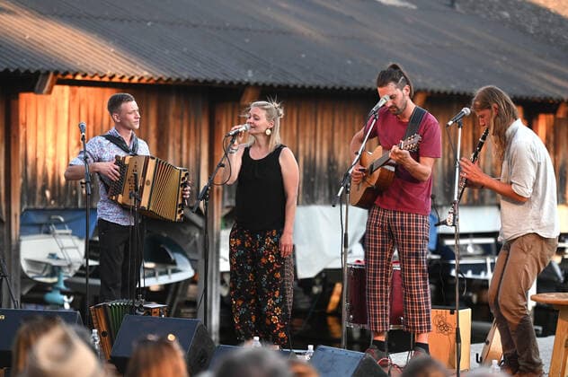 Concert of the Peter Mayer Hofkapelle, In the Bootswerft Frauscher in Gmunden, as part of the Salzkammergut Festwochen Gmunden, on 09 07 21 The picture shows from l to r Andreas Jamnik, Styrian harmonica and vocals, Nora Mayer, vocals and percussion, Peter Mayer, guitar and vocals, Mic