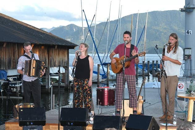 Concert of the Peter Mayer Hofkapelle, In the Bootswerft Frauscher in Gmunden, as part of the Salzkammergut Festwochen Gmunden, on 09 07 21 The picture shows from l to r Andreas Jamnik, Styrian harmonica and vocals, Nora Mayer, vocals and percussion, Peter Mayer, guitar and vocals, Mic