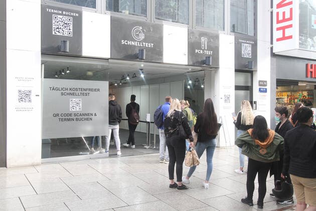 Large crowd of people wanting to take a free Corona quick test in front of a Corona testing center in the pedestrian zone and shopping street Zeil in downtown Frankfurt, Hesse, Germany