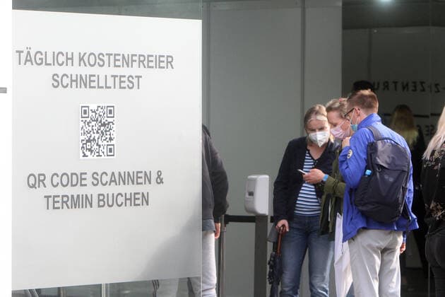Large crowd of people wanting to take a free Corona quick test in front of a Corona testing center in the pedestrian zone and shopping street Zeil in downtown Frankfurt, Hesse, Germany