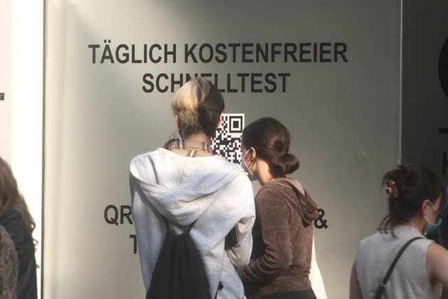Large crowd of people wanting to take a free Corona quick test in front of a Corona testing center in the pedestrian zone and shopping street Zeil in downtown Frankfurt, Hesse, Germany