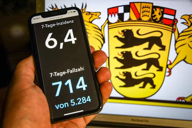 Coronavirus in Deutschland - Covid-19-Dashboard des Robert Koch-Institut DEU, Deutschland, Baden-Württemberg, 12.07.2021: Die 7-Tage-Inzidenz für das Bundesland (Fälle letzte 7 Tage 100.000 EW) wird auf einem iPhone angezeigt, im Hintergrund das Landeswappen