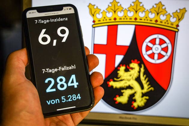 Coronavirus in Deutschland - Covid-19-Dashboard des Robert Koch-Institut DEU, Deutschland, Rheinland-Pfalz, 12.07.2021: Die 7-Tage-Inzidenz für das Bundesland (Fälle letzte 7 Tage 100.000 EW) wird auf einem iPhone angezeigt, im Hintergrund das Landeswappen