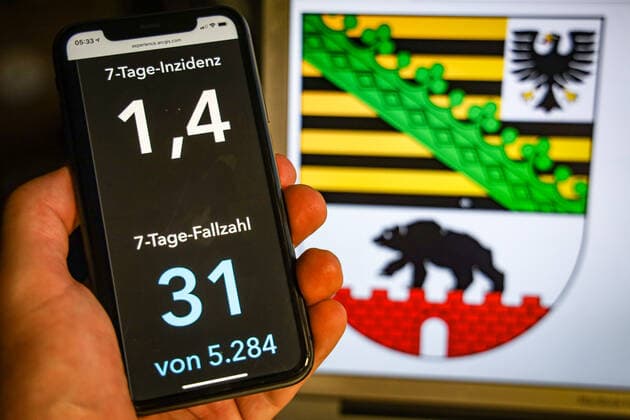 Coronavirus in Deutschland - Covid-19-Dashboard des Robert Koch-Institut DEU, Deutschland, Sachsen-Anhalt, 12.07.2021: Die 7-Tage-Inzidenz für das Bundesland (Fälle letzte 7 Tage 100.000 EW) wird auf einem iPhone angezeigt, im Hintergrund das Landeswappen