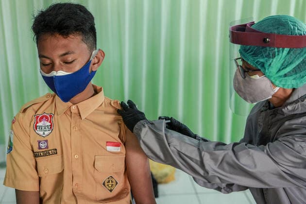 July 14, 2021, Malang, Indonesia: A health worker administers a coronavirus vaccine to a child at Naval Base in Malang..The Indonesian Ministry of Health has started to roll out Phase Three Vaccinations for Vulnerable People, Other General People, and Children aged 12-17 years. Malang Indonesia - ZUMAs197 20210714_zaa_s197_006 Copyright: xBayuxNovantax