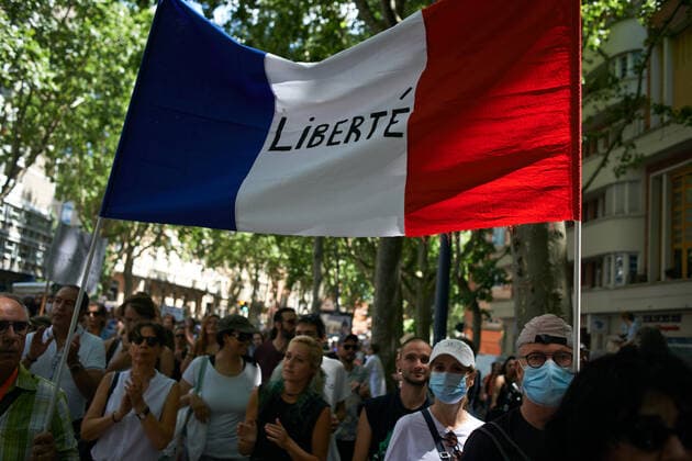 Coronavirus in Frankreich, Impfgegner protestieren in Toulouse Protest Against The Health Pass And The Near Mandatory Vaccination Protesters wolk with a french flag reading Freedom . Thousands of people protested in Toulouse and elsewhere in France against the near mandatory vaccination and against the health pass after the Macron s speech on July 12th. Macron announced the health pass will be mandatory for going in public places such as cafes, theates, concerts hall, shops, public transportation (train, bus, tramway), etc. The delay between the first jab and the health pass obtention will be five weeks. But the prohibition for public spaces for non-vaccinated people will go on August 1st. Some say its alike apartheid and 2nd class citizens. Toulouse. France. July 17th 2021 Toulouse France pitton-n  Copyright: xAlainxPittonx
