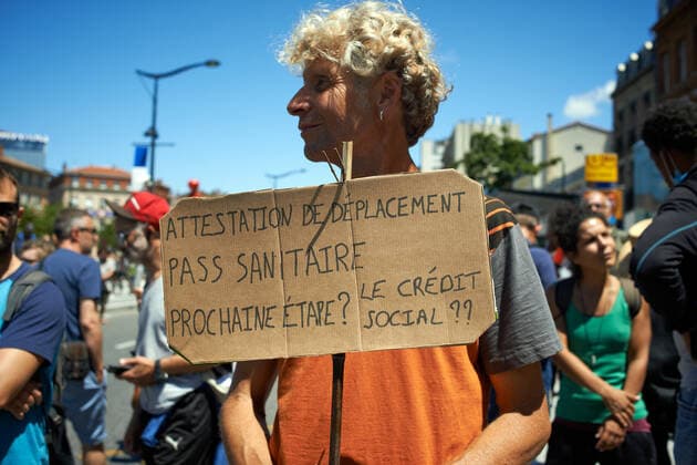 Coronavirus in Frankreich, Impfgegner protestieren in Toulouse Protest Against The Health Pass And The Near Mandatory Vaccination A man has a placard reading Certificate of movement, health pass, next stop ? social credit ? Thousands of people protested in Toulouse and elsewhere in France against the near mandatory vaccination and against the health pass after the Macron s speech on July 12th. Macron announced the health pass will be mandatory for going in public places such as cafes, theates, concerts hall, shops, public transportation (train, bus, tramway), etc. The delay between the first jab and the health pass obtention will be five weeks. But the prohibition for public spaces for non-vaccinated people will go on August 1st. Some say its alike apartheid and 2nd class citizens. Toulouse. France. Copyright: xAlainxPittonx