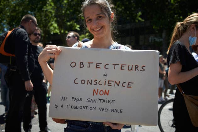 Coronavirus in Frankreich, Impfgegner protestieren in Toulouse Protest Against The Health Pass And The Near Mandatory Vaccination A young woman holds a cardboard reading conscientious objector, no to the health pass . Thousands of people protested in Toulouse and elsewhere in France against the near mandatory vaccination and against the health pass after the Macron s speech on July 12th. Macron announced the health pass will be mandatory for going in public places such as cafes, theates, concerts hall, shops, public transportation (train, bus, tramway), etc. The delay between the first jab and the health pass obtention will be five weeks. But the prohibition for public spaces for non-vaccinated people will go on August 1st. Some say its alike apartheid and 2nd class citizens. Toulouse. France. July 1  Copyright: xAlainxPittonx