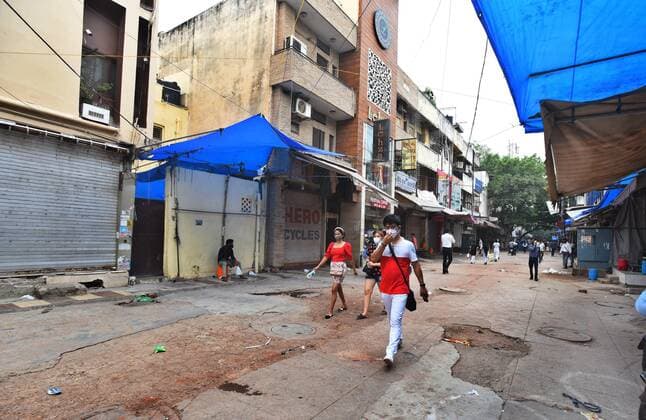 NEW DELHI, INDIA - JULY 18: People walk past the closed shops at export market in Delhi s Sarojini Nagar after it was shut down by authorities for violating Covid-19 protocols, on July 18, 2021 in New Delhi, India. (Photo by Raj K Raj Hindustan Times) Shoppers Flout Covid Norms In Delhi s Sarojini Market