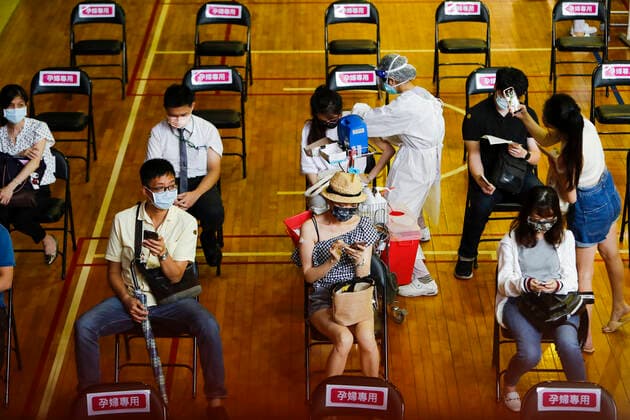 July 21, 2021, Taipei, Taipei, Taiwan: A lady takes pictures of her friend who is getting inoculated with the vaccine against the coronavirus, at a vaccination site inside National Taiwan University Hospital, as the island is discussing the possibility of lowering the Covid-19 alert to a level 2. The island has been offering AstraZeneca, Moderna and Medigrn vaccines to boost its immunity rate. Taipei Taiwan - ZUMAs313 20210721_zip_s313_006 Copyright: xDanielxCengxShou-Yix