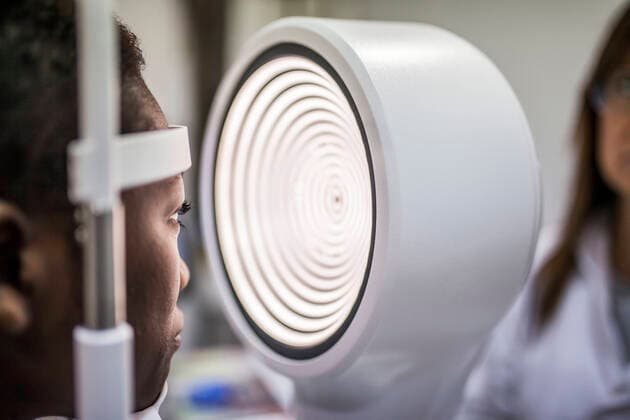 Black woman in optometry cabinet during study of the eyesight using a modern corneal topographer, Model released DavidFuentes_Optometry_17.jpg Copyright: xDavidxFuentesx MR