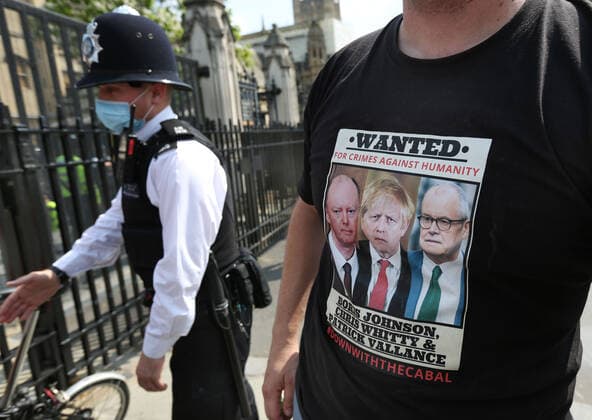 July 21, 2021, London, United Kingdom: A protester wears a t-shirt calling for the arrest of Prime minister Boris Johnson and leading civil servants with a police officer in the background, during the demonstration..English weather forecaster, businessman, activist, Piers Corbyn with other protesters met outside the House of Commons at Parliament Square to protest against Vaccine passports and other Coronavirus restrictions that he feels the public are being softened up to accept as the new normal. London United Kingdom - ZUMAs197 20210721_zaa_s197_223 Copyright: xMartinxPopex