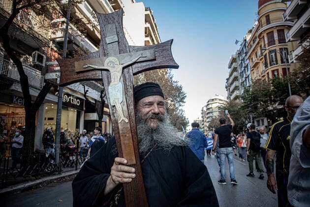Demonstration Against The Mandatory Vaccine In Thessaloniki A priest holds a cross during a Demonstration Against The Mandatory Vaccine was held in Thessaloniki and Athens in Greece on Wednesday July 21, 2021. One week after the massive protest against the mandatory vaccination the anti-vaxx campaign continues with a big group protesting in the streets of the city of Thessaloniki. The protest was organized via social media by anti-vaccination believers. According to the group more than 40.000 people participated, while the police estimated unofficially slightly around 15.000 people participating in the demonstration. As the Greek government is passing a legislation with mandatory vaccination to specific job sectors like medical healthcare  Copyright: xNicolasxEconomoux