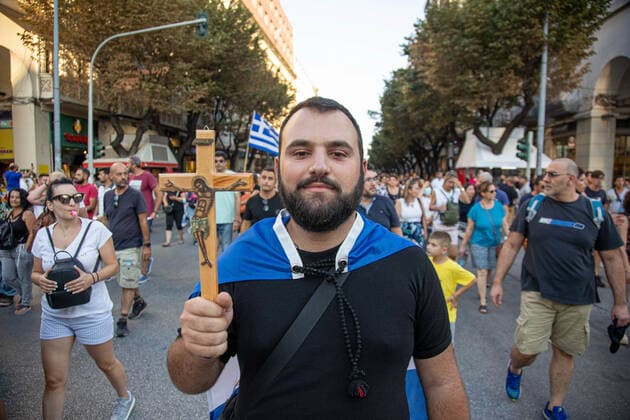 Demonstration Against The Mandatory Vaccine In Thessaloniki A young male protester is holding a cross with Jesus and carrying the Greek Flag during the Demonstration Against The Mandatory Vaccine was held in Thessaloniki and Athens in Greece on Wednesday July 21, 2021. One week after the massive protest against the mandatory vaccination the anti-vaxx campaign continues with a big group protesting in the streets of the city of Thessaloniki. The protest was organized via social media by anti-vaccination believers. According to the group more than 40.000 people participated, while the police estimated unofficially slightly around 15.000 people participating in the demonstration. As the Greek government is passing a legislation with mandatory  Copyright: xNicolasxEconomoux