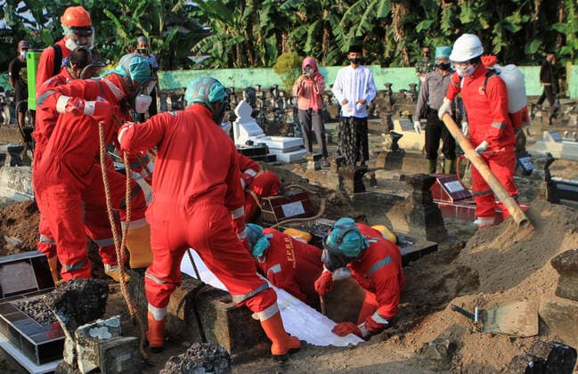 Coronavirus in Indonesien, Beerdigung von Covid-19-Toten auf Friedhof in Yogyakarta Indonesia Is The New Epicenter of Asia Covid-19 Funeral workers lower the coffin of a victim of the Covid-19 coronavirus at a cemetery in Yogyakarta, on July 22, 2021. Indonesia overtakes India as Asia s new Covid-19 epicenter. Indonesia has reported the highest numbers of Covid-19 cases and deaths in Southeast Asia. 