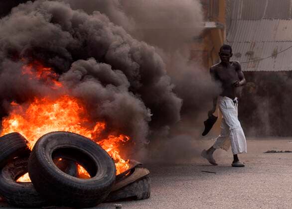 Bilder des Jahres 2021, News 07 Juli News Themen der Woche KW29 News Bilder des Tages A man walks in front of a pile of burning tires during a day of protests in Cap-Haitien, Haiti, 22 July 2021. Demonstrators demanding justice to Moise set up bonfires and barricades in different points of the city, at the northern of the country, where the latest president was born. Jovenel s staunch supporters do not want his funeral, scheduled for Friday, to take place until his murderers are dead. At the moment, 26 people have been arrested for their alleged involvement in the case. Haitians pay tribute assassinated President Jovenel Moise among protests !ACHTUNG: NUR REDAKTIONELLE NUTZUNG!  Copyright: xOrlandoxBarriax AME4469 20210722-47ca8439274c31b091c0e870edd0de6a1111270c