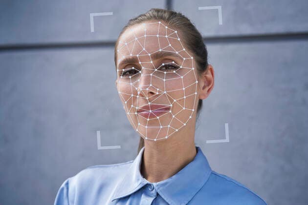 Businesswoman with facial recognition biometrics in front of wall model released Symbolfoto property released ABIF01401